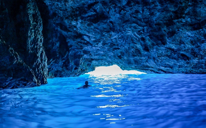Swimming in the vibrant waters of a blue cave.