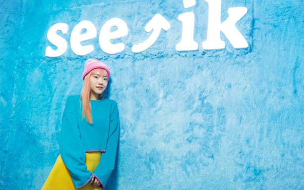 Person posing in front of Seeik Studio sign, Seoul.