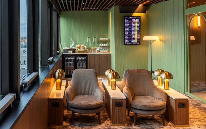 Lounge seating area with chairs and lamps at Plaza Premium First, Terminal 1, Fiumicino Airport.