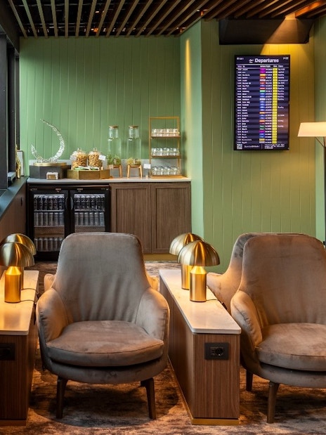 Lounge seating area with chairs and lamps at Plaza Premium First, Terminal 1, Fiumicino Airport.
