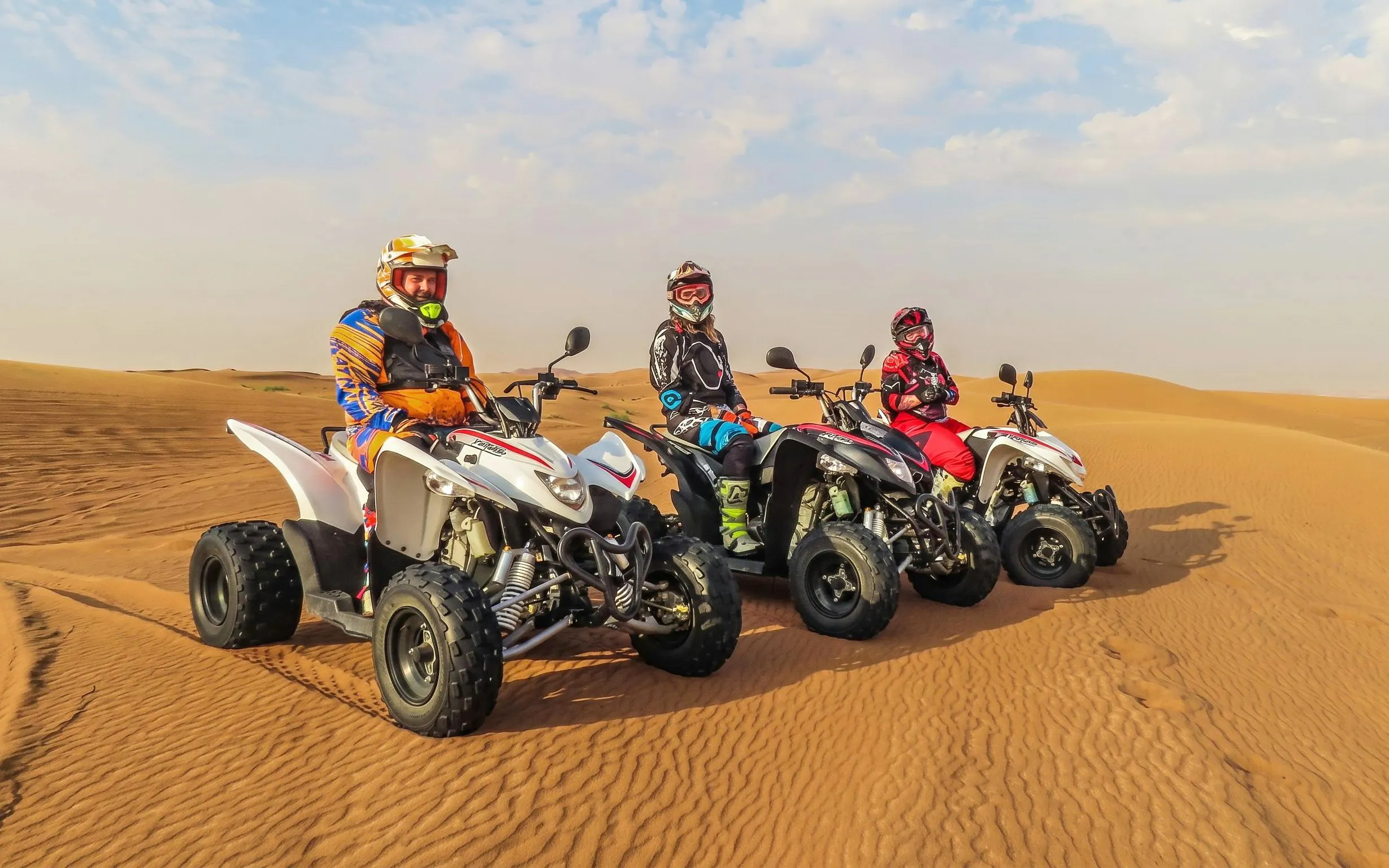 Quad biking adventure in Dubai desert with riders on sand dunes.