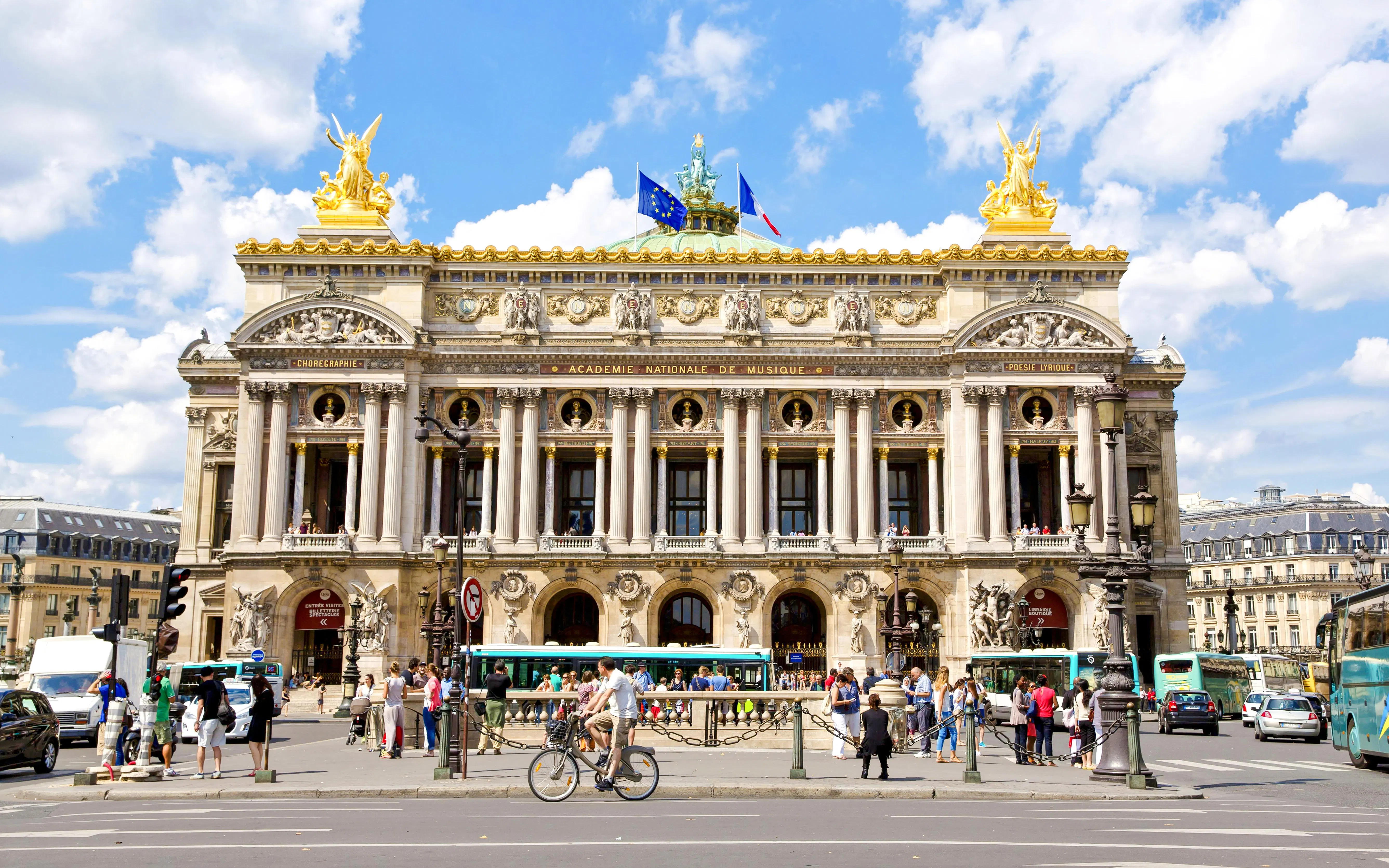 Palais Garnier facade with people and traffic, Paris walking tour.