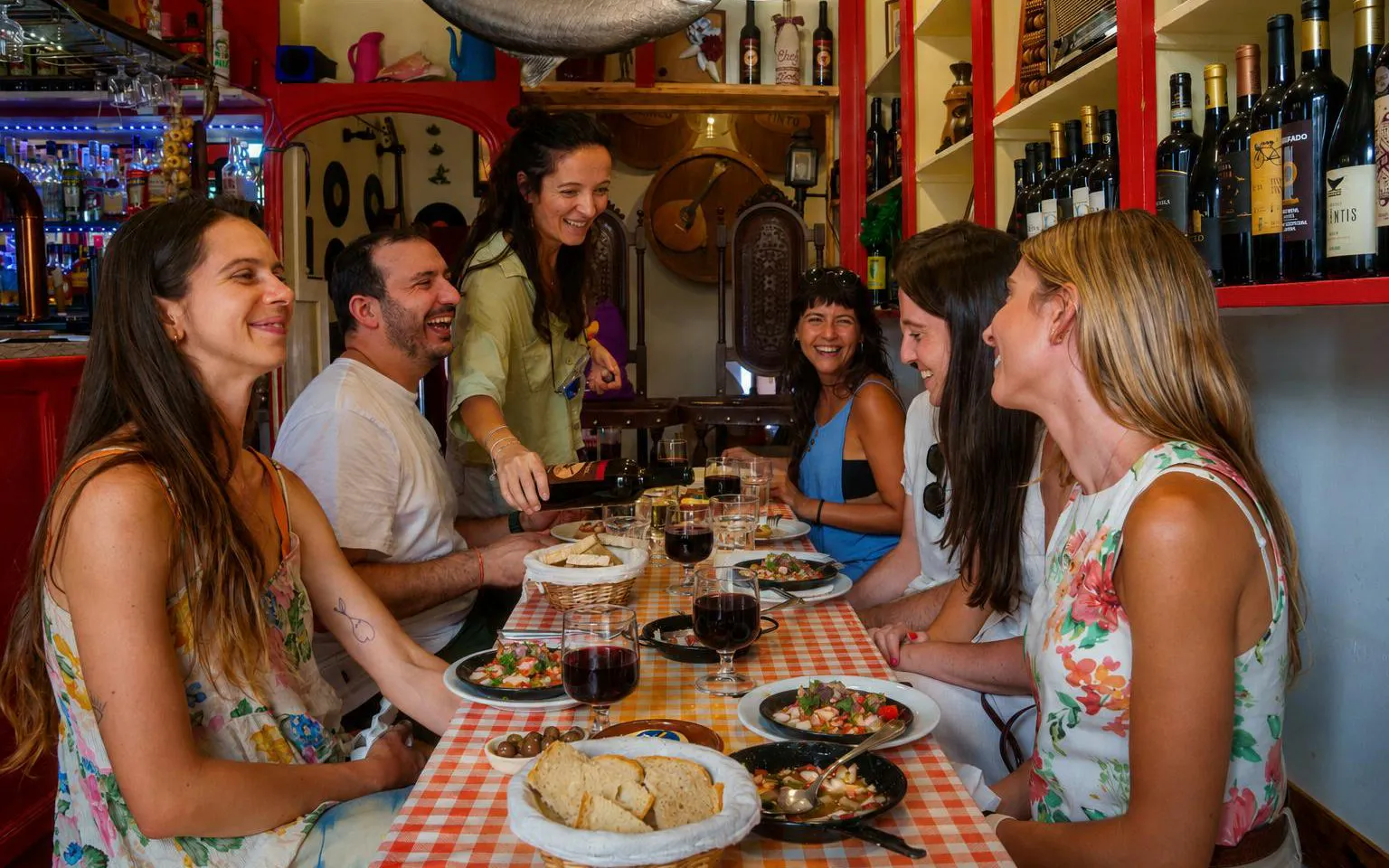 Group enjoying traditional Portuguese dishes and wine at a Lisbon restaurant.