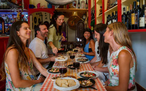 Group enjoying traditional Portuguese dishes and wine at a Lisbon restaurant.