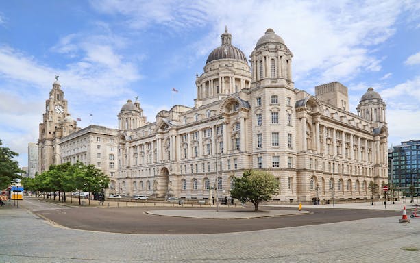 Port of Liverpool Building with hop on hop off bus nearby.