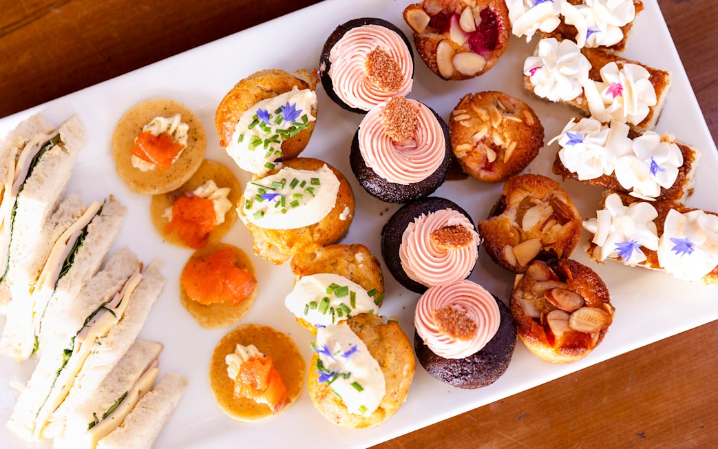 Assorted desserts and sandwiches on a platter for onboard dining experience.
