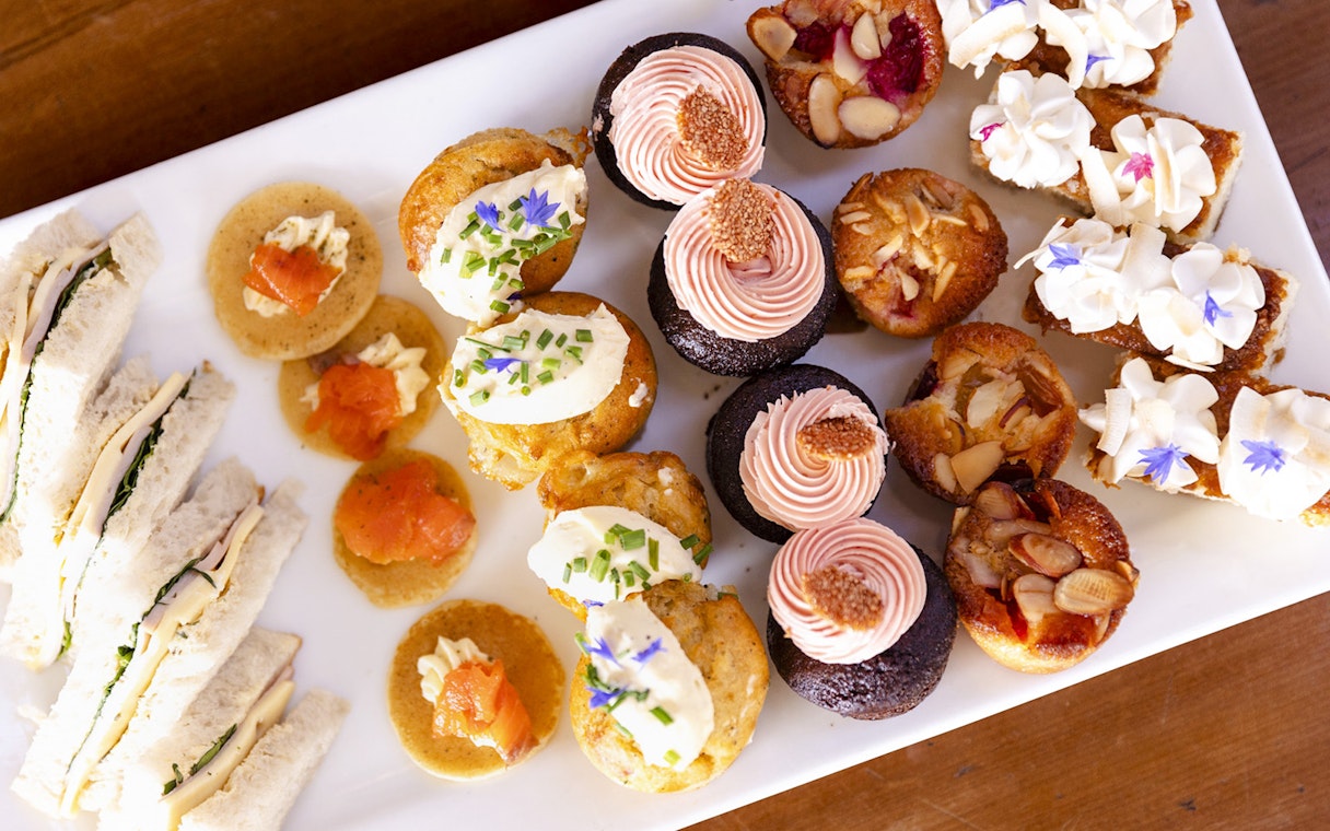 Assorted desserts and sandwiches on a platter for onboard dining experience.