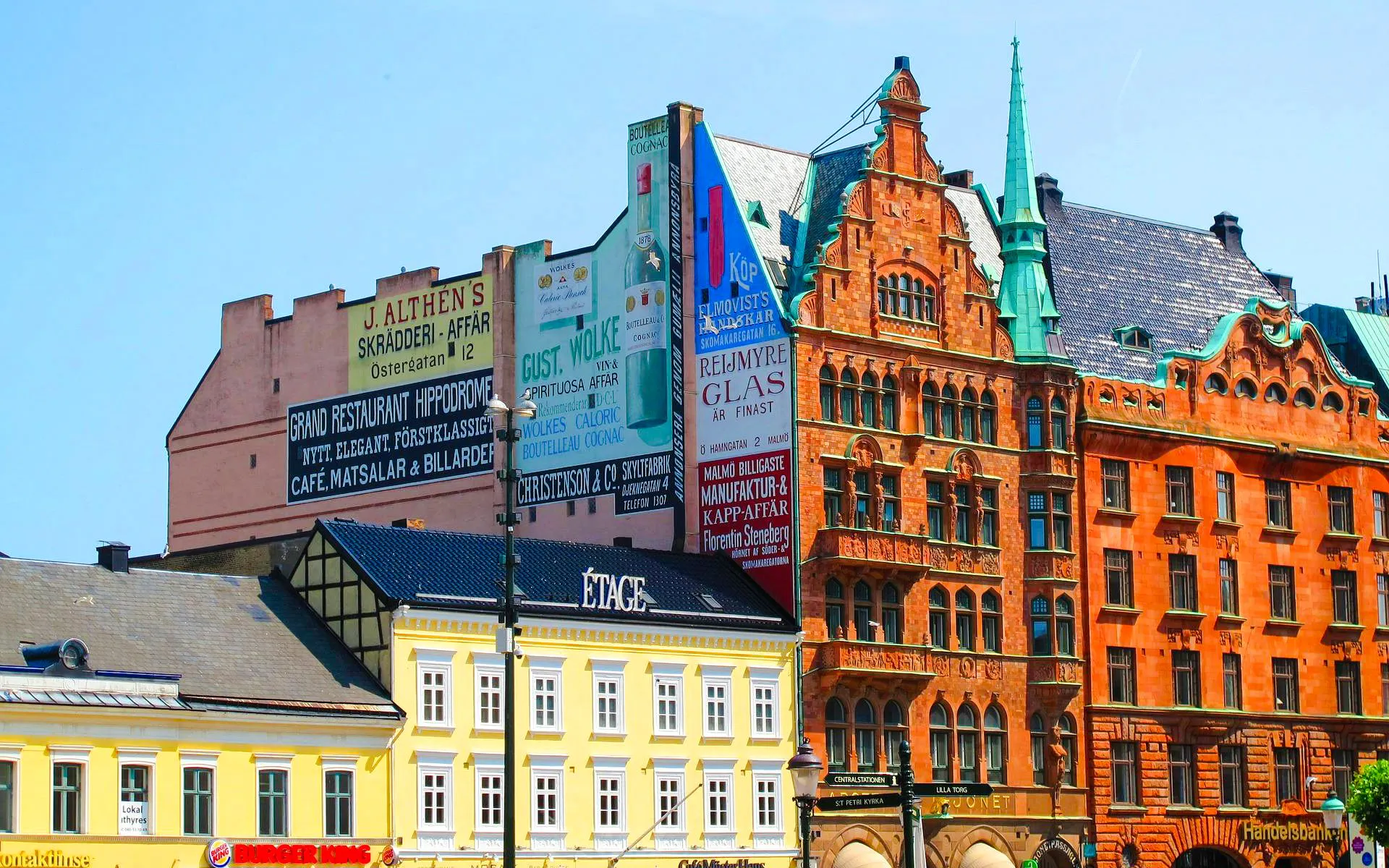 Colorful historic buildings in Malmo, Sweden, featuring ornate architecture and vintage advertisements.