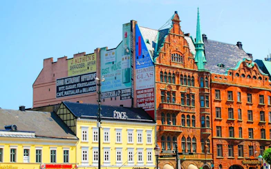 Colorful historic buildings in Malmo, Sweden, featuring ornate architecture and vintage advertisements.
