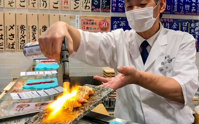 Chef torching sushi at a Shibuya food tour in Tokyo, Japan.