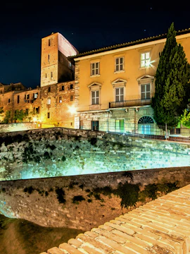 Museum of San Pietro illuminated at night with historic architecture and stone walls.