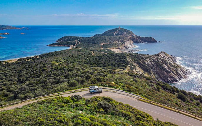 4x4 vehicle on coastal road with view of Chia's beaches and mountains, Cagliari tour.