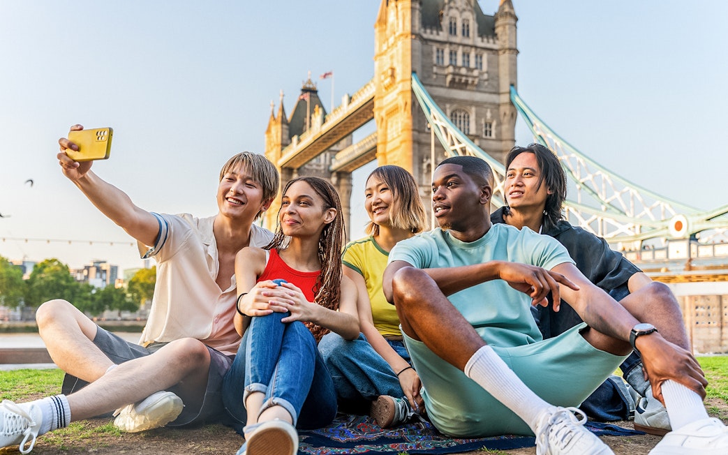 Tourists taking a selfie with Tower Bridge in London, showcasing exclusive access with Tower Bridge Tickets.