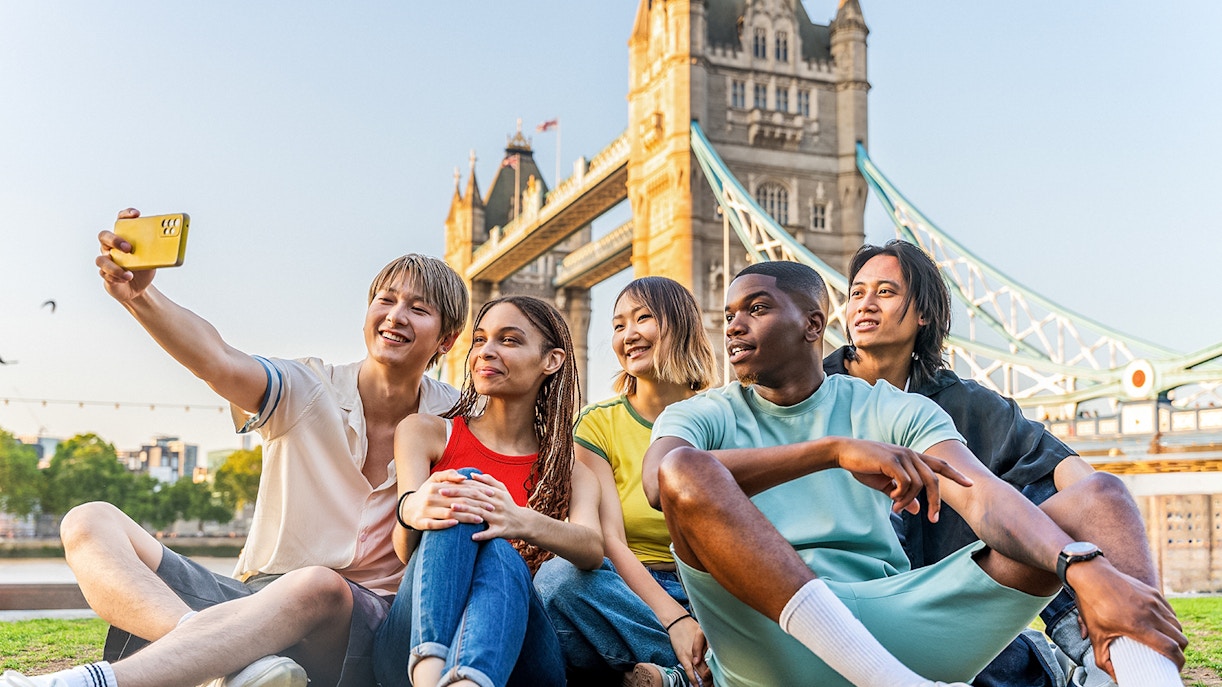 Tourists taking a selfie with Tower Bridge in London, showcasing exclusive access with Tower Bridge Tickets.