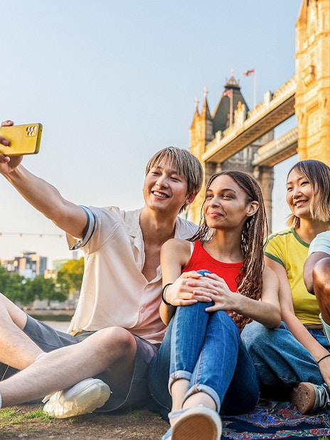 Tourists taking a selfie with Tower Bridge in London, showcasing exclusive access with Tower Bridge Tickets.