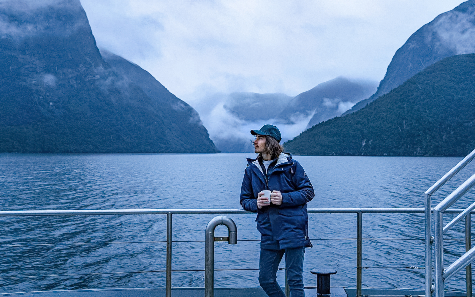 Cruise passenger on deck with Doubtful Sound fjord view, Te Anau.