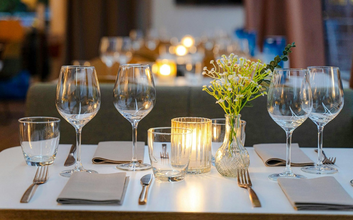 Dinner table setup with wine glasses and candles on a Stavanger dinner cruise.