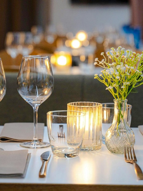 Dinner table setup with wine glasses and candles on a Stavanger dinner cruise.