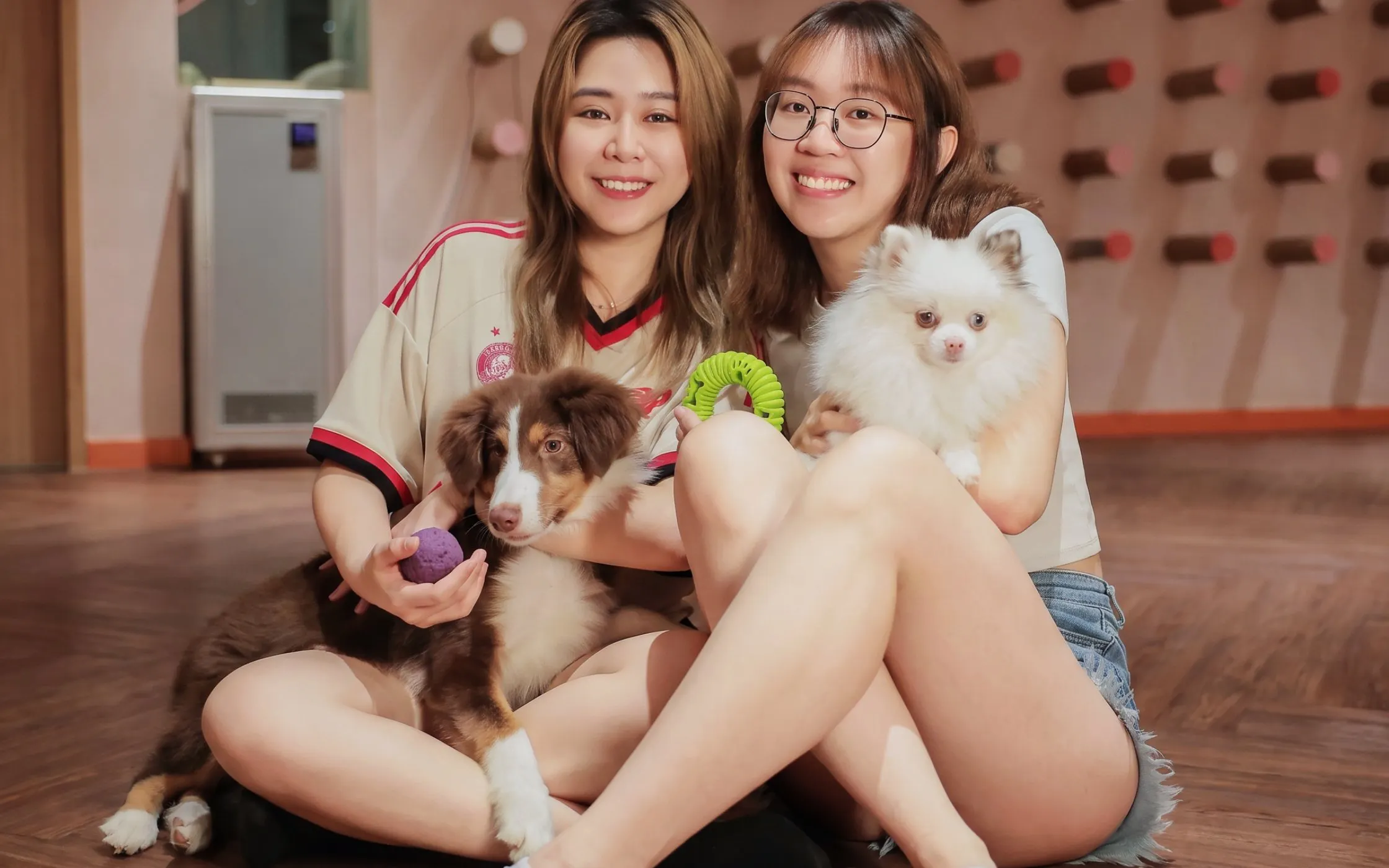 Two people holding dogs at Just Pets Megastore.