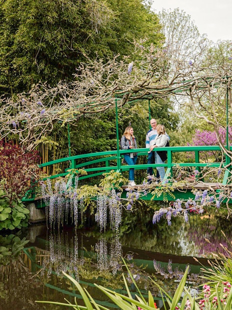 Visitors on Monet's Japanese bridge in Giverny garden during Musée d'Orsay tour.