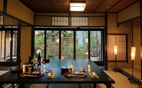 Kaiseki dinner table setup in Kyoto lifestyle museum with garden view.