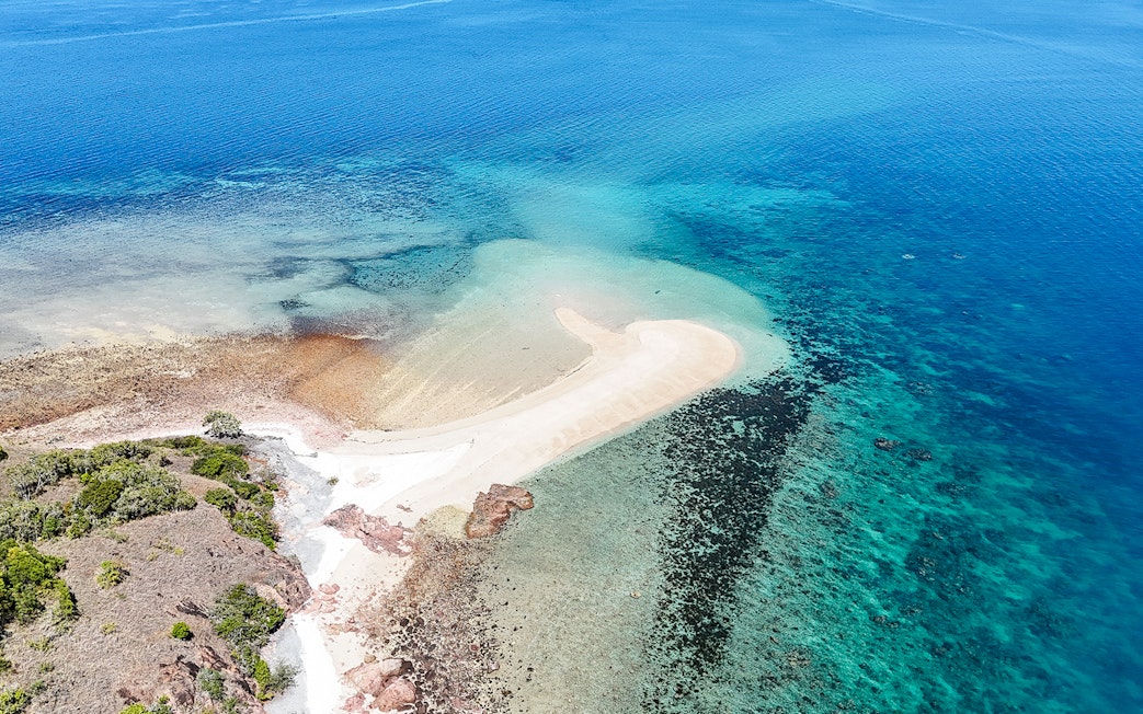 Aerial view of Upolu Cay with sandy beach and surrounding turquoise waters.