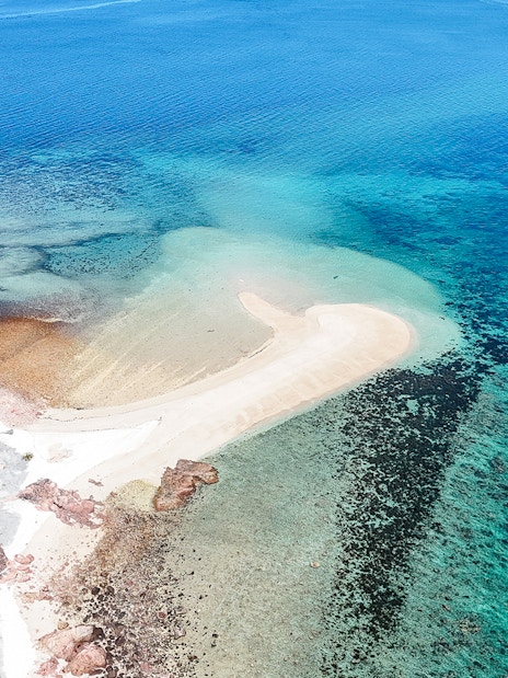 Aerial view of Upolu Cay with sandy beach and surrounding turquoise waters.