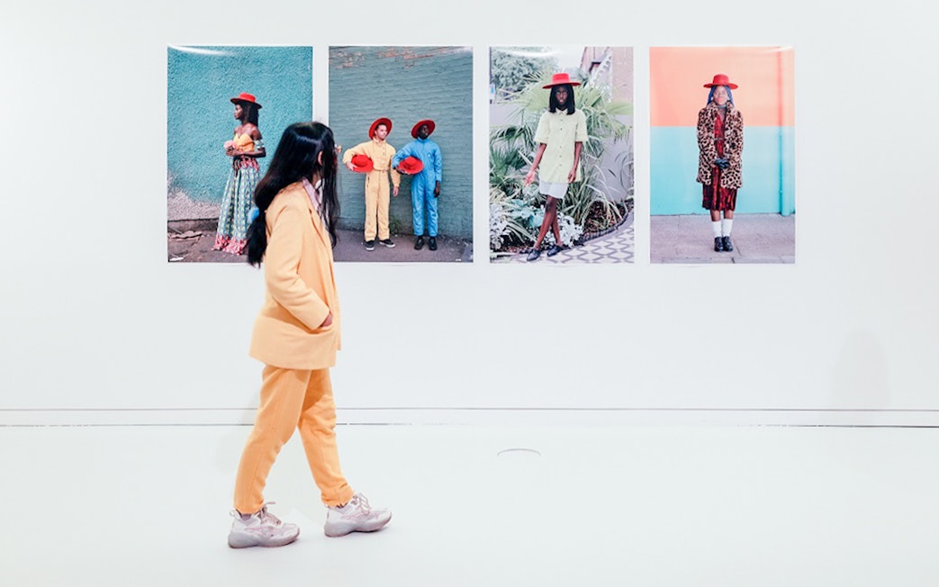 Visitor viewing colorful portraits at MAAT Gallery, Lisbon.