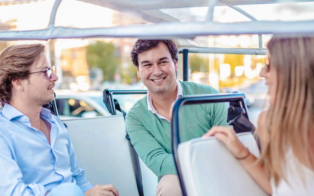 Passengers enjoying eco tuk tuk tour in Madrid.