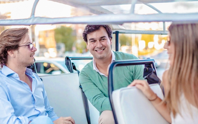 Passengers enjoying eco tuk tuk tour in Madrid.