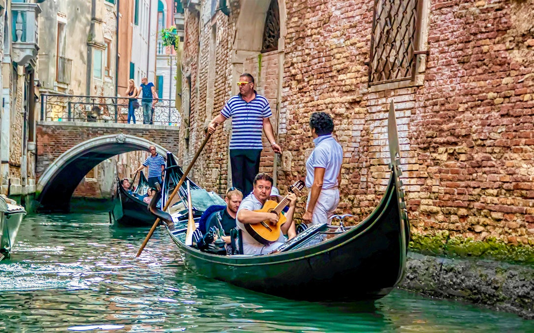 Gondola ride with musician serenading in Venice canal.