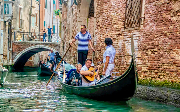 Gondola ride with musician serenading in Venice canal.