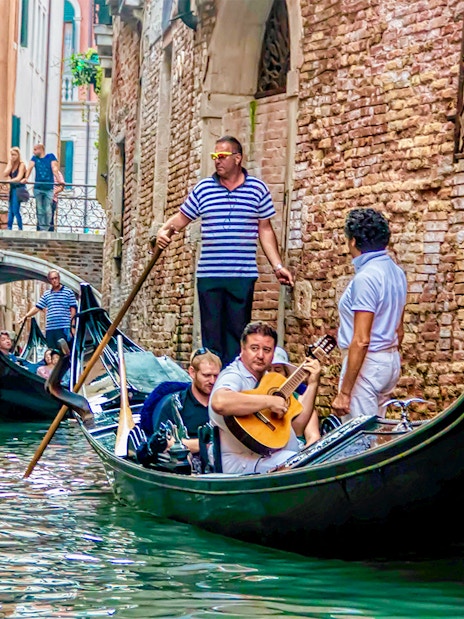 Gondola ride with musician serenading in Venice canal.
