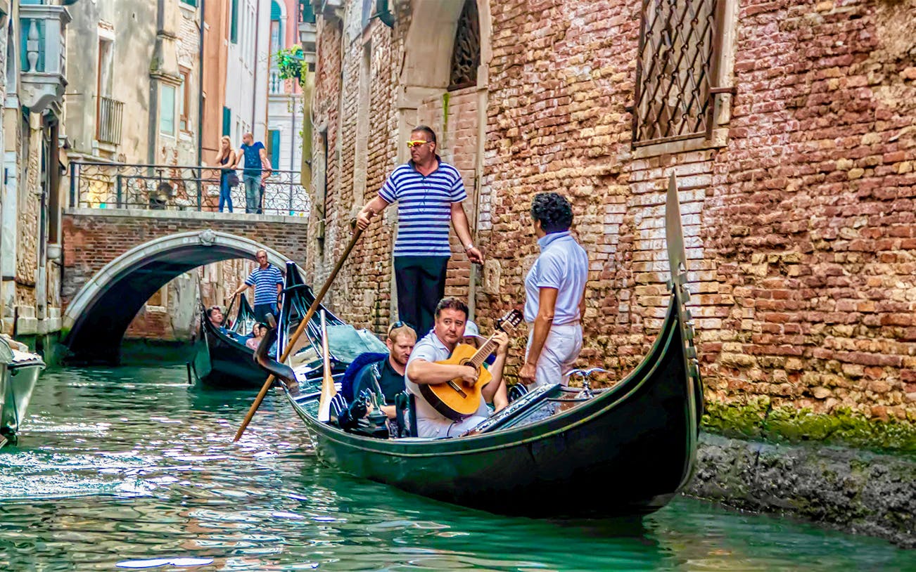 Gondola ride with musician serenading in Venice canal.