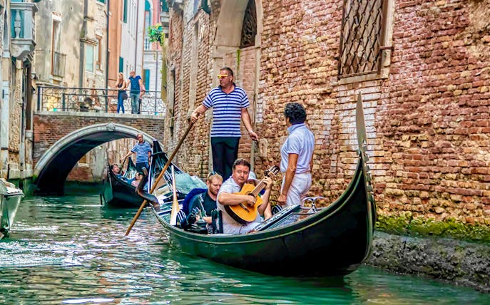 Gondola ride with musician serenading in Venice canal.