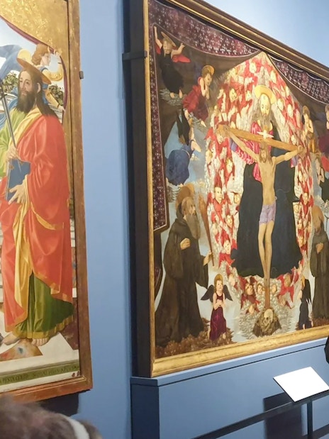 Visitors viewing Alesso Baldovinetti's "The Trinity and Saints Benedict and Giovanni Gualberto" at Accademia Gallery, Florence.