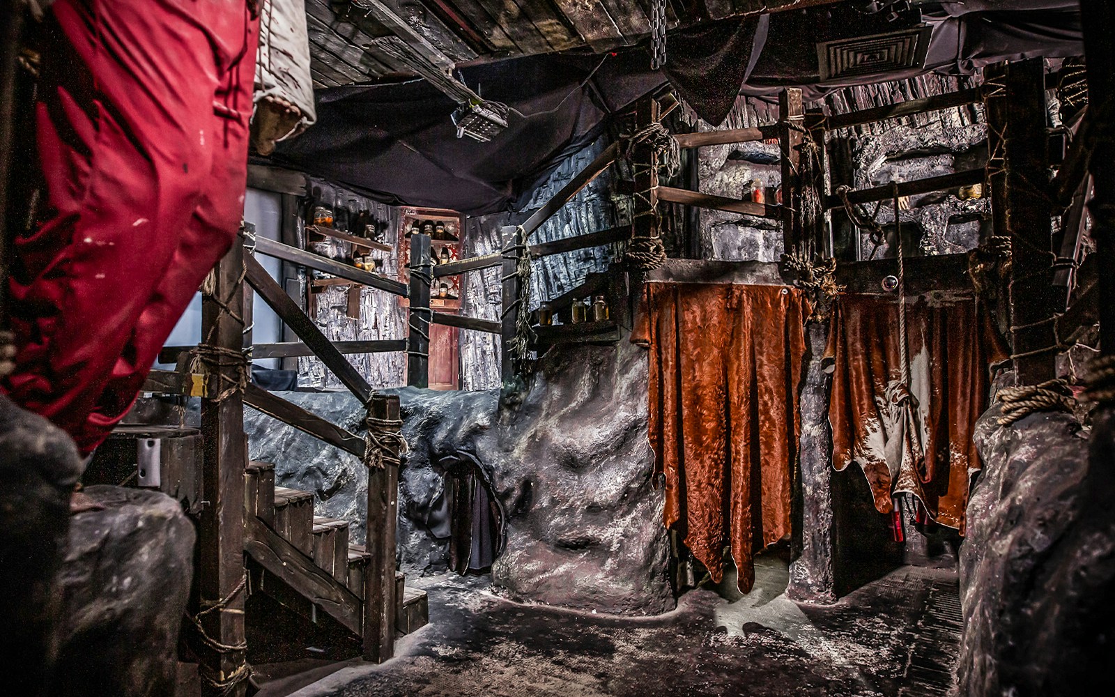 Edinburgh Dungeon Cannibal Cave with rocky walls and hanging red drapes.