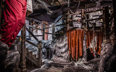 Edinburgh Dungeon Cannibal Cave with rocky walls and hanging red drapes.