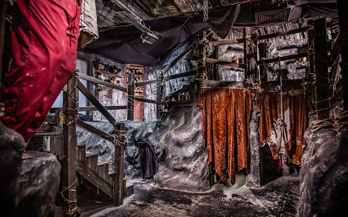 Edinburgh Dungeon Cannibal Cave with rocky walls and hanging red drapes.
