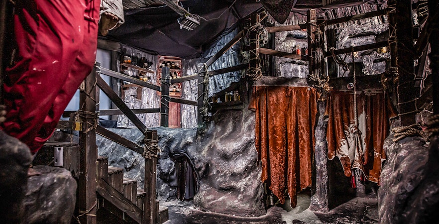 Edinburgh Dungeon Cannibal Cave with rocky walls and hanging red drapes.