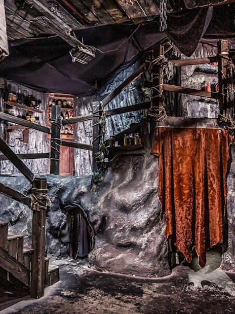 Edinburgh Dungeon Cannibal Cave with rocky walls and hanging red drapes.