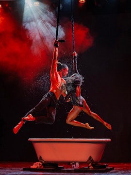 Aerial performers above a bathtub at Paris Paradis show.