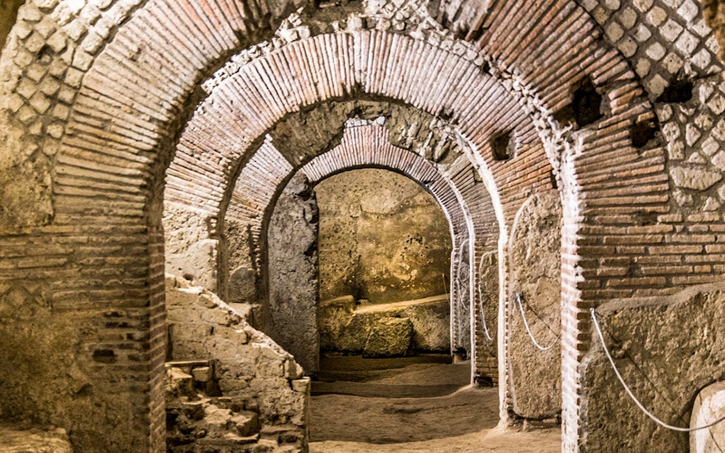 Underground ruins with ancient brick arches in Naples city tour.