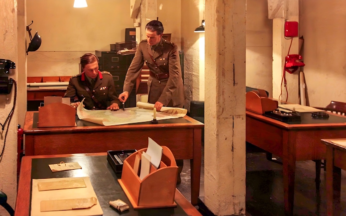Military officers examining maps in Churchill's War Rooms, London.
