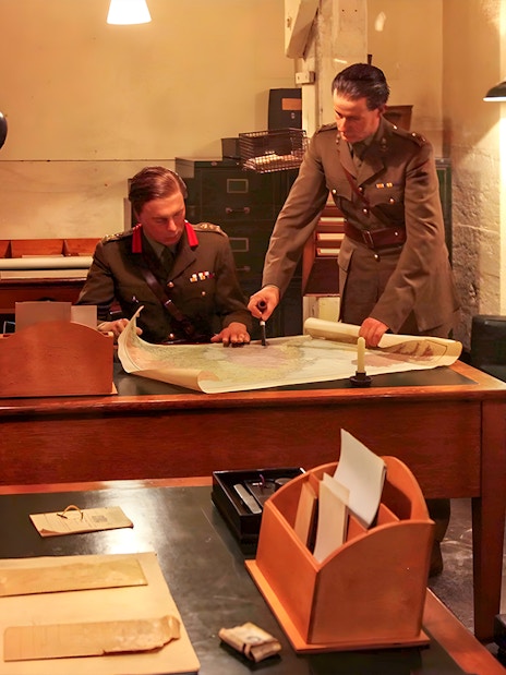 Military officers examining maps in Churchill's War Rooms, London.