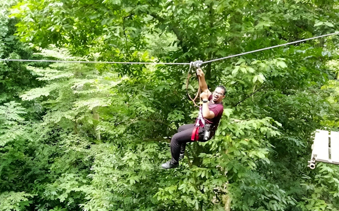 Person ziplining through lush forest at Skytrex Adventure Langkawi.