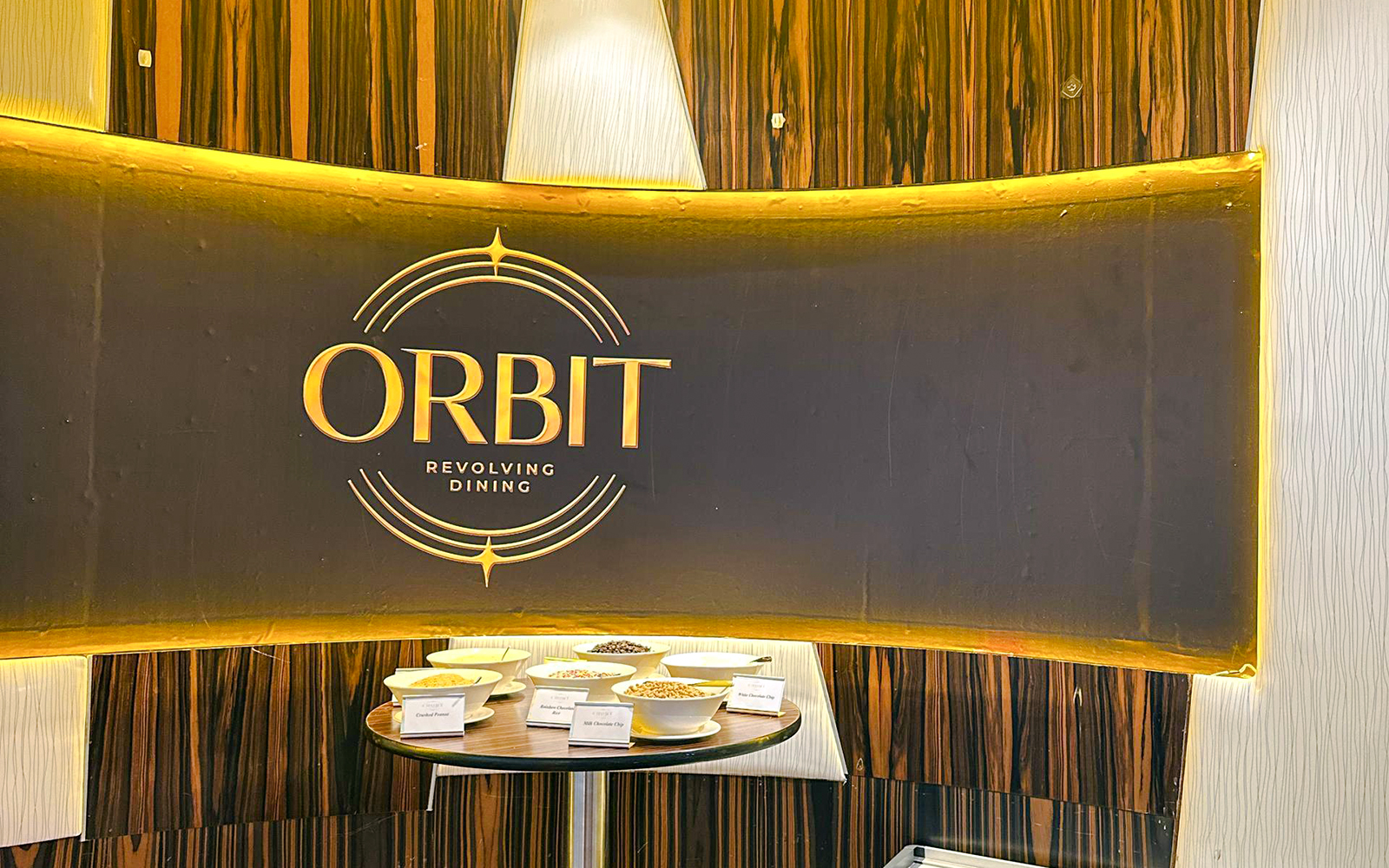 Entrance of lunch buffet at ORBIT Revolving Dining, KL Tower, with various dishes displayed.