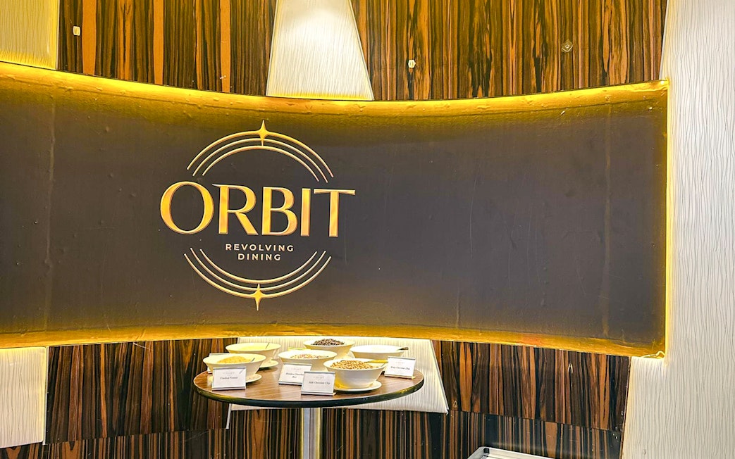 Entrance of lunch buffet at ORBIT Revolving Dining, KL Tower, with various dishes displayed.