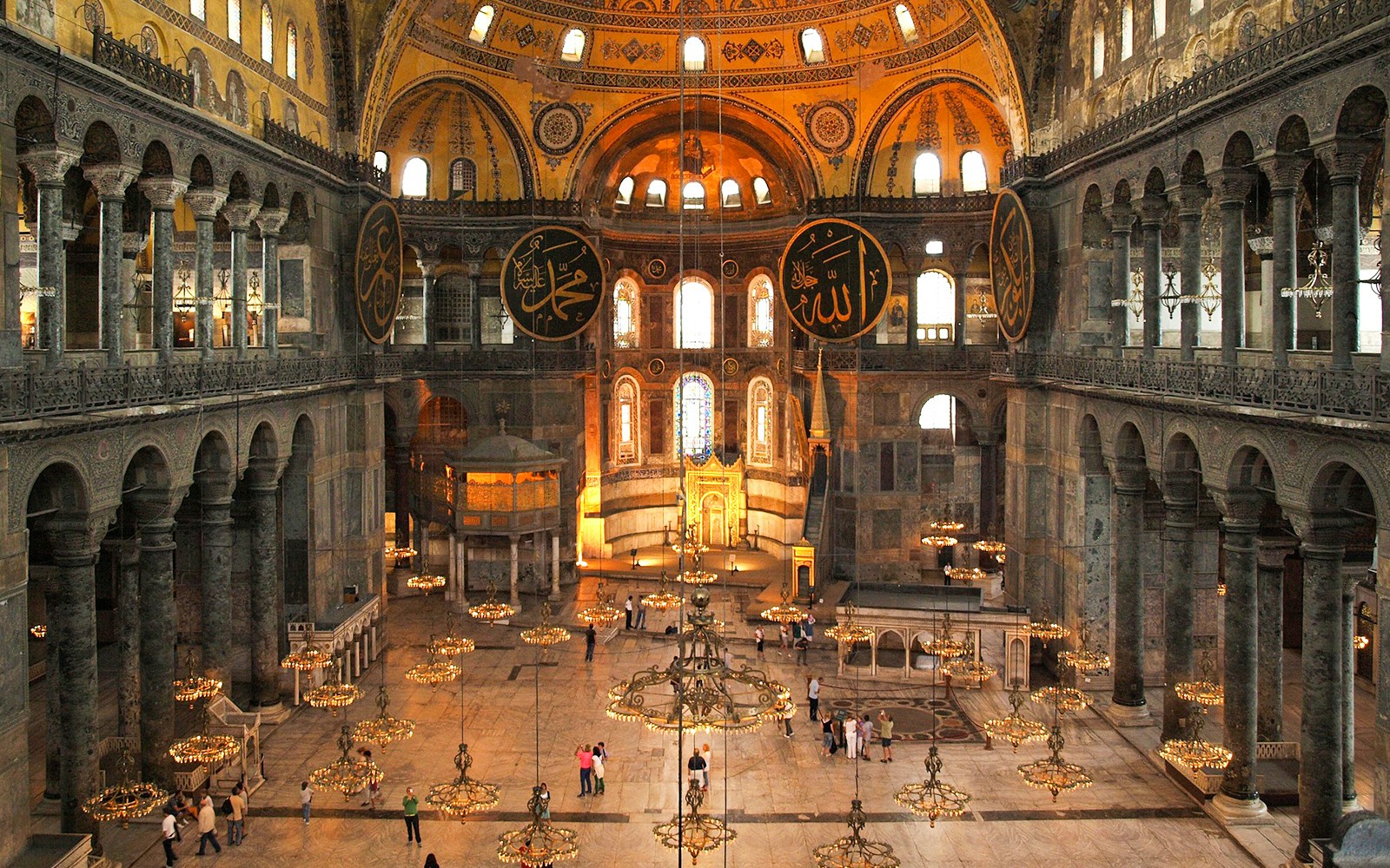 Interior view of Hagia Sophia with visitors exploring the historic architecture in Istanbul.