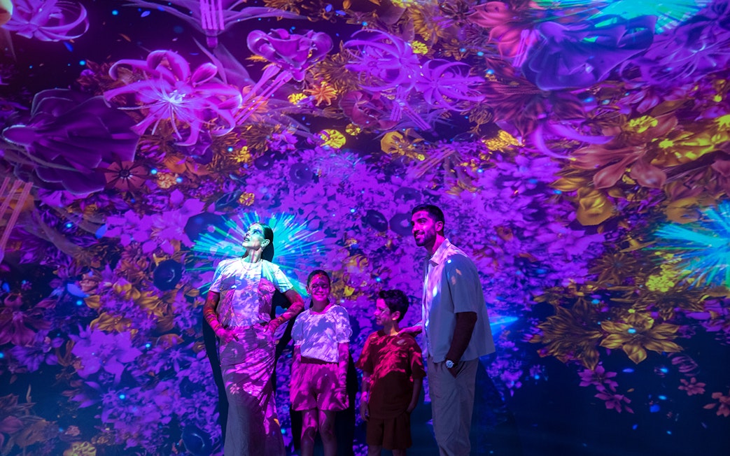 Visitors enjoying vibrant digital art at Source installation, AYA Universe.